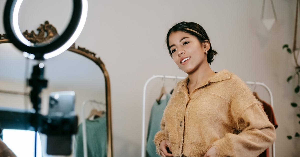 A female influencer in front of a ring light used for making video content