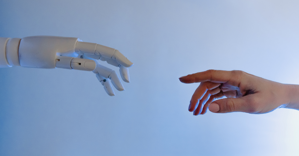 A robotic hand reaching out to a human hand.