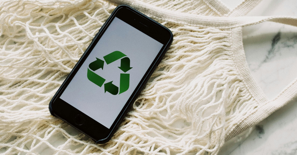 A phone displaying a recycling logo on a white background